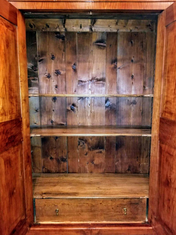 Interior of Austiran wild cherry Biedermeier linen press with two adjustable shelves and a drawer.