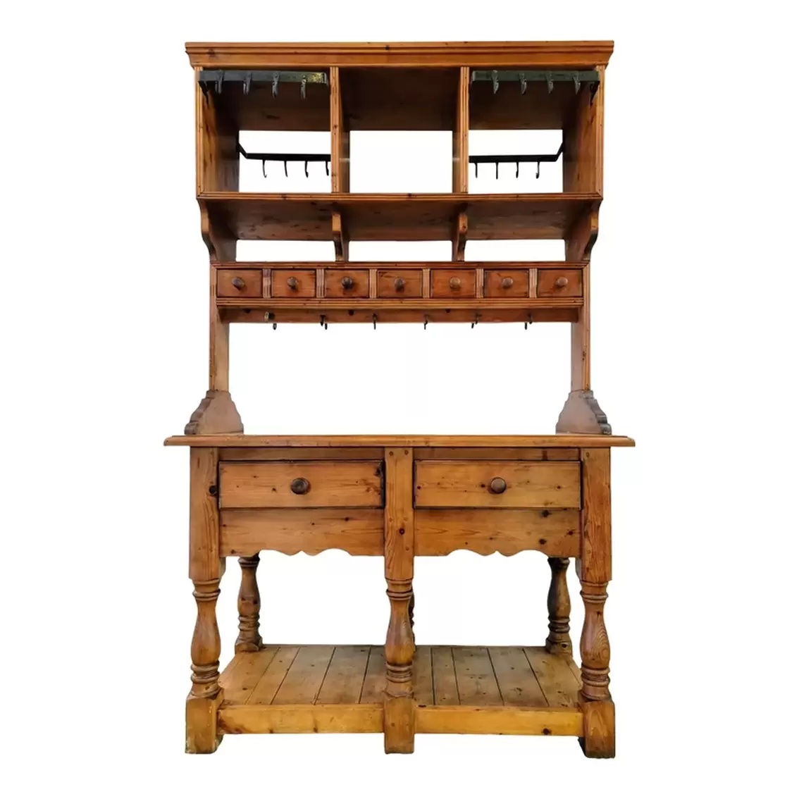 Late-19th-century European pine baker's table and rack was designed for use on both sides as all drawers are retractable from either side; the open cubbies and lower self are accessible from either side; and both sides are fitted with iron utensil racks.  The flat top offers storage possibilities outside of the pigeon holes, spice drawers, frieze drawers, and bottom slat-constructed open shelf.  The shaped side supports, molded edges, serpentine aprons, and turned baluster legs add interest.  The drawers open on either side with a tug on the turned wooden knob pulls.  The baker's table is inset with a white, grey, and yellow marble top.