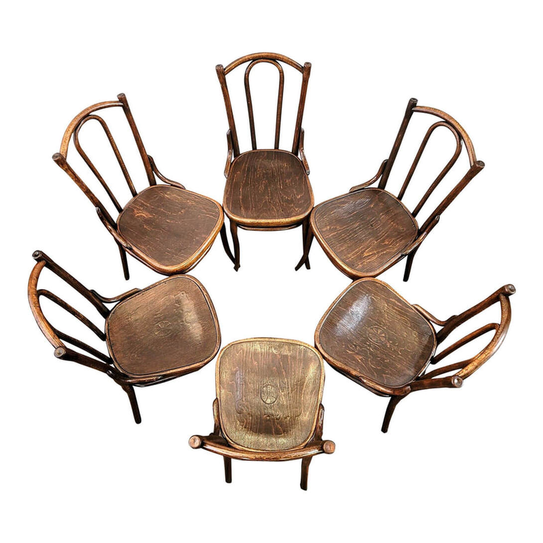 Set of six chairs in a circle. The chairs are a Thonet cafe style made about 1906. The backs, legs, and stretchers are bent wood. The seats feature pressed patterns and are inset into the chair.