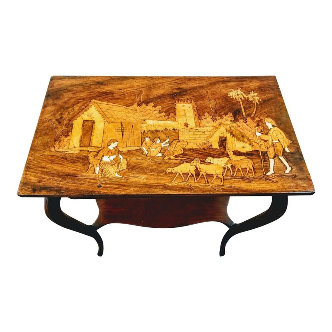 Antique rosewood parlor table with cabriole jambes (French legs that were introduced in French furniture in the late Louis XIV style) and a shaped lower shelf. The top features a sadeli (marquetry) village goat herding scene with a background showing mud architecture and a pair cooking at a pot over a fire. The scene is created with various woods and bone.  Sadeli, or marquetry, is a folk art specialty of craftspeople in Surat, Gujarat, India. Surat was the first headquarters and trading outpost established by the English East India Company in 1608, which led to British Raj in India.