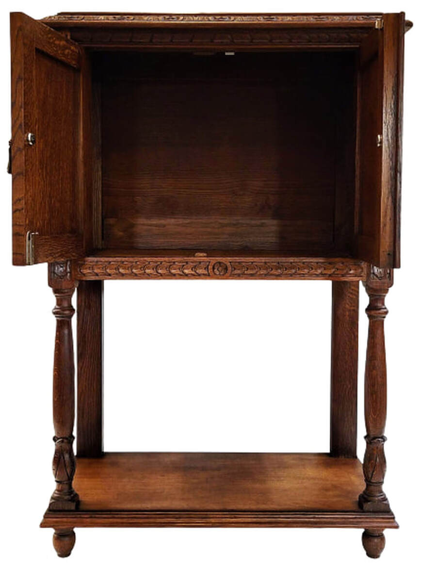 Interior of Medieval Revival oak liquor cabinet on stand.