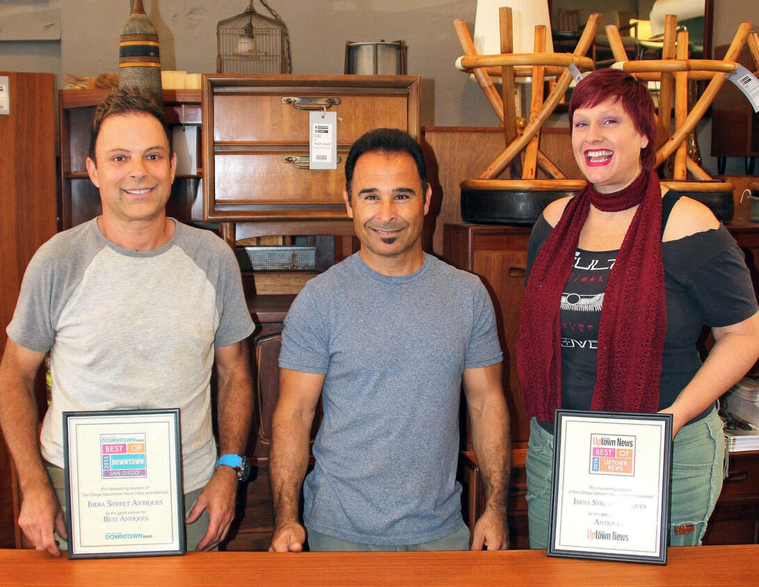 Three staff members from India Street Antiques / Danish Modern San Diego exhibiting two of their fourteen community choice awards. Photo is clickable to access the SDVoyager interview.